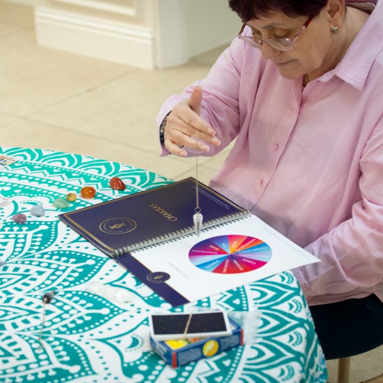 Reflexology a hand gently massages the foot of a person, adorned with colourful bracelets.